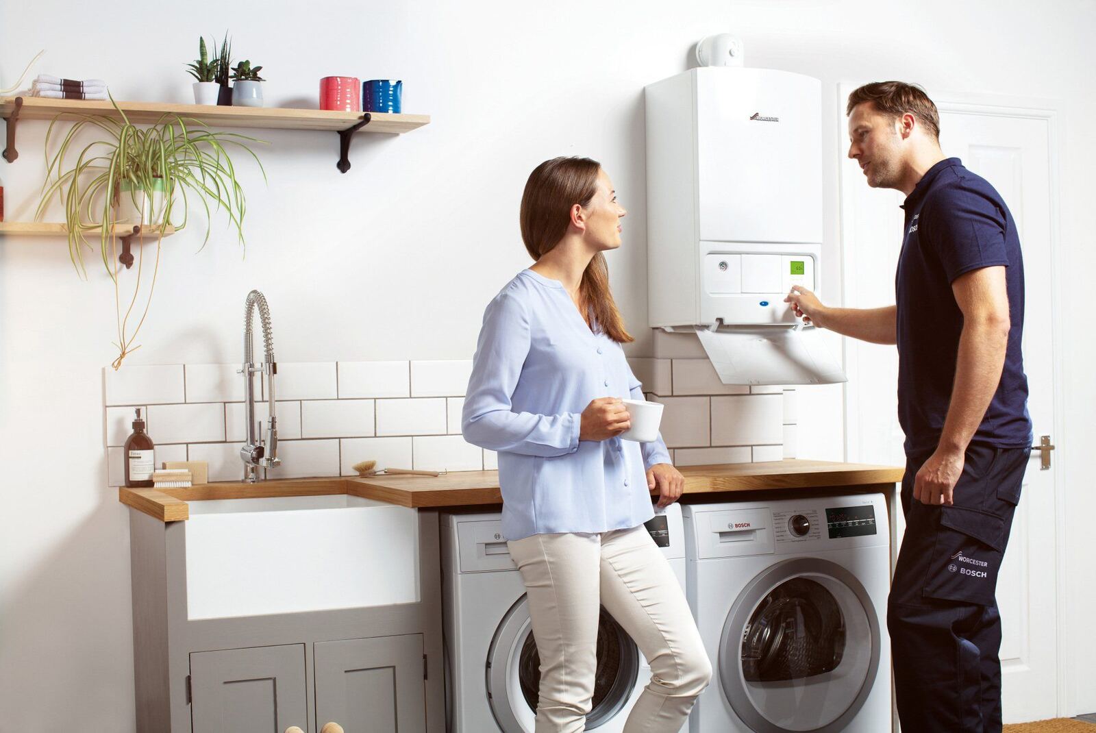 A heating engineer explaining a newly installed combi boiler to a homeowner